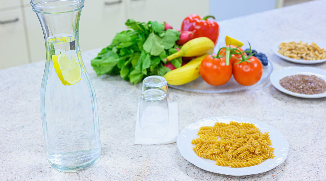 Nudeln und Wasser mit Obst und Gemüse auf dem Tisch der Park Klinik