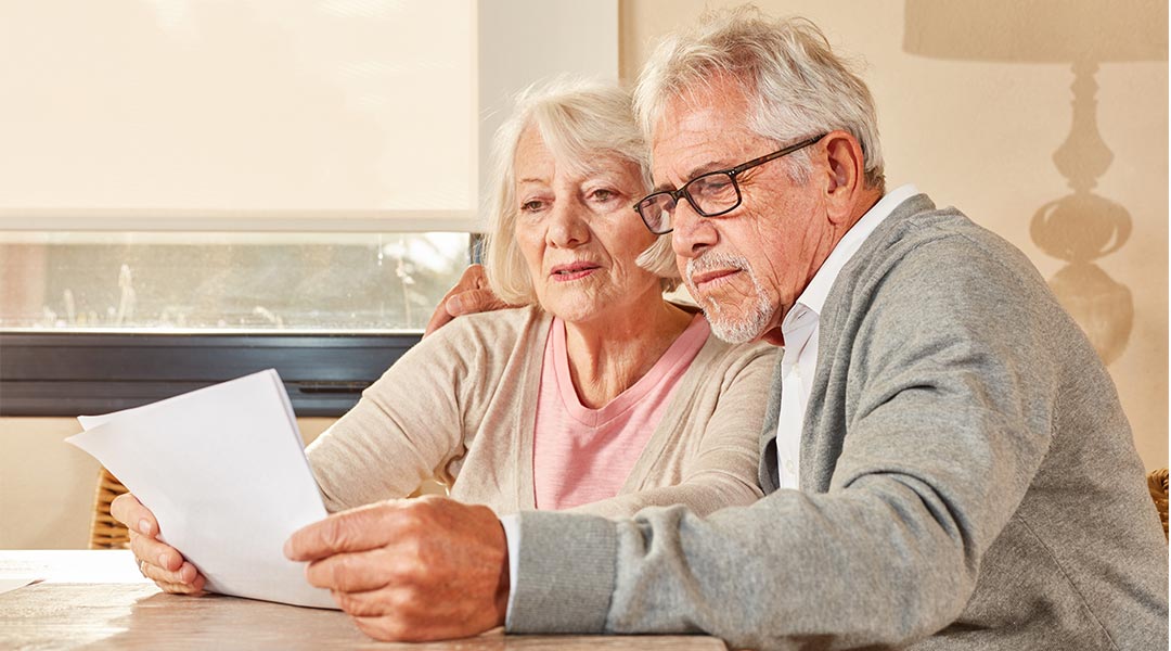 Senioren Paar liest zusammen einen Vorsorge Plan